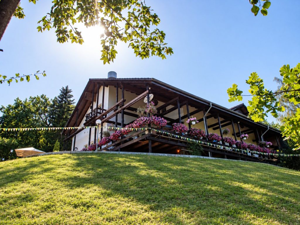 Haupthaus des Eifeltor Erlebnisparks mit Blumenkaesten, Wimpelketten und Aussichtsterrasse